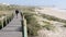 People stroll on the wooden boardwalk near Espinho beach, Portugal