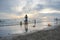 People strolling on the beach in the evenings at Rayong Beach. Tourists play in the sea in the evening.