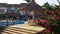 People sunbathing on the loungers by the pool at Hotel Resort with Blue Pool, Palm Trees and Sunbeds in Egypt