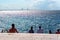 People sunbathing on sea front of Baltic Sea and the Oresund Bridge on summer in, Malmo, Sweden. Selective focus