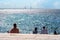 People sunbathing on sea front of Baltic Sea and the Oresund Bridge on summer in, Malmo, Sweden. Selective focus