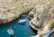 People sunbathing at Wied iÅ¼-Å»urrieq inlet among cliffs