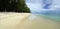 People in a sunny day walking on the public beach of Flic en Flac with tropical trees on edge of Indian Ocean, Mauritius