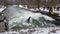 People surfing in winter at the Eisbach standing wave in Munich, Germany