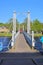 People on suspension footbridge crossing river