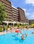People swim in pool of hotel Flamingo Grand Hotel at summer sunny day