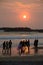 People taking sunset stroll on beach