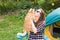 People, tourism and nature concept - Woman in sunglasses stroking a cat sitting near the tent