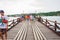 People and tourists sightseeing at Uttama Nusorn Wooden Bridge, Mon bridge