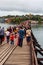 People and tourists sightseeing at Uttama Nusorn Wooden Bridge, Mon bridge