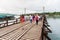 People and tourists sightseeing at Uttama Nusorn Wooden Bridge, Mon bridge