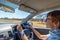 People traveling concept. Woman driving car with hands on steering wheel. Interior close up, selective focus on one hand, side vie