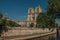 People, tree-lined Seine River and gothic Notre-Dame Cathedral at Paris.