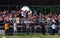 People on tribunes applause to reenactors.