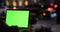 People typing green screen laptop computer at night