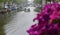 People under umbrellas enjoy boating on the Amsterdam canal.