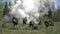 People in uniform on background of military hand grenade explosion in forest.