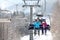 People using chairlift at mountain ski resort.