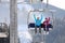 People using chairlift at mountain ski resort.