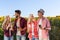 People using smart phone chatting group friends outdoor countryside sunflowers field