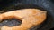 People using a wooden spatula to grilling a piece of slice salmon steak, preparing and cooking the food, selective focus shallow d