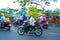 People Vietnamese driving a motorbike with holder flower or kumquat pot behind