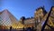 People viewing Louvre Museum glass pyramid constructions in Paris, France