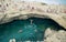 People visit Grotta Della Poesia swimming cave in Roca, Salento Peninsula, Italy