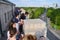 People visit the top, upper terrace of the Arch of Triumph with panoramic views towards the city.