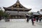 People visit wooden pavilion of main hall decorated with paper lanterns of Yasaka Shrine