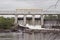 People wade in water by huge Chute Pond dam