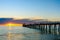 People wailking along jetty at sunset