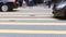 People waiting to cross street, pedestrian crossing on busy road, detail of the legs of a crowd