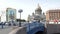 People walk across the bridge amid urban traffic and parked tourist buses near St. Isaac`s Cathedral