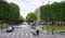 People walk along the Champs Elysees and Franklin Delano Ruzvelt Avenue. On the avenue the car is moving