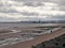 People walk along a dirty looking beach