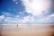 People walk along empty beach with Blue clear sky in summer