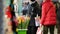 People walk along an underground passage past small street shops with souvenirs and gifts. A bucket of fresh tulips on the eve of