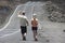 People walk by the asphalt road over volcanic lava in Sainte-Rose De La Reunion, France.