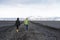 People walk on black sand beach in south Iceland