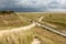 People walk on boardwalk at Kniepsand beach, Wittdun, Amrum island, North Frisia, Germany