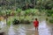 People walk through the flooded farms