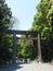 People walk through the large Torii entrance gate of the famous Meiji-Jingu Shinto Shrine, located in Shibuya, Tokyo, Japan.