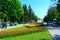 People walk in the park with flower beds and fountains