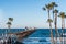 People Walk Among Shops of Oceanside Fishing Pier