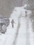 People walk on a snow-covered city road.