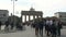 People walk take pictures ride bicycles at the Brandenburg Gate