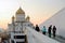 People walk towards the Christ the Saviors church at dawn.