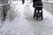 People walk on uncleaned sidewalk, slippery and icy sidewalk