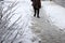 People walk on uncleaned sidewalk, slippery and icy sidewalk